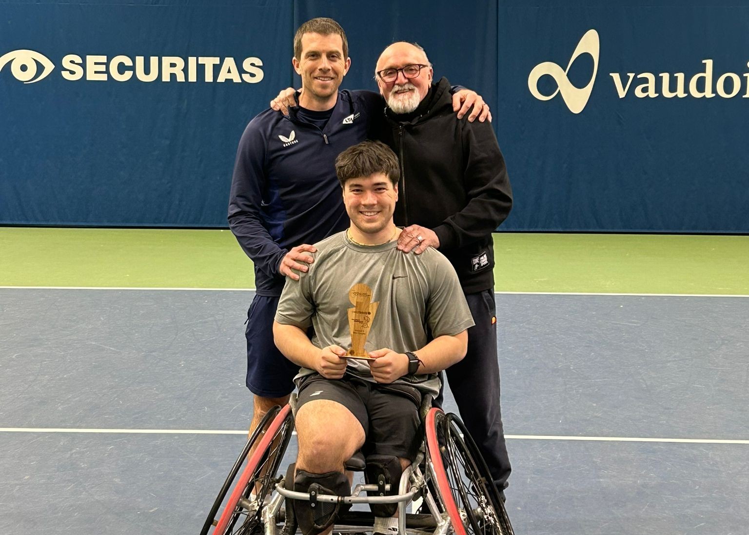 Dahnon Ward holding an ITF Wheelchair Tennis title in Switzerland