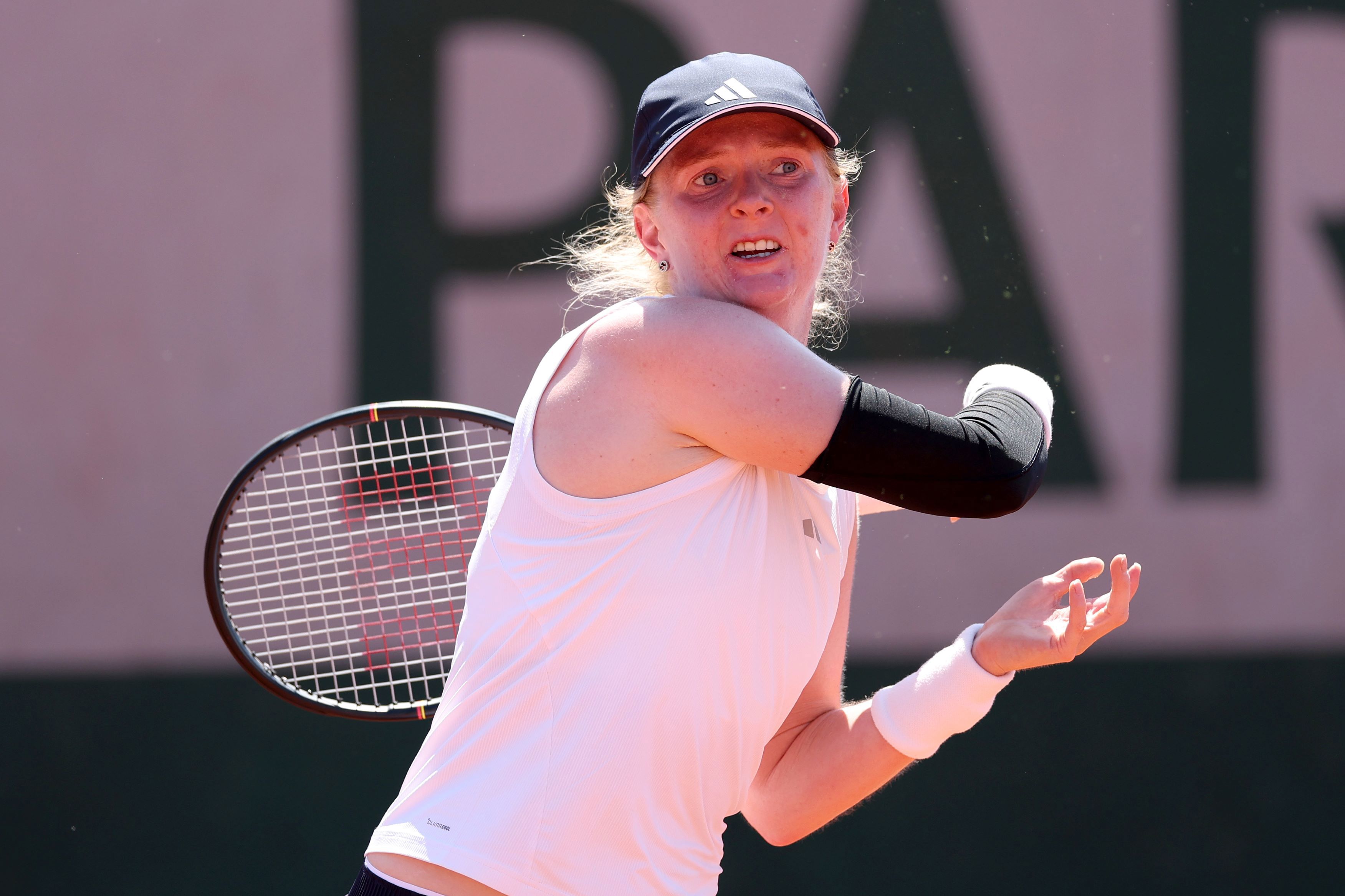 British tennis player Francesca Jones extends her racket across her body after striking the ball
