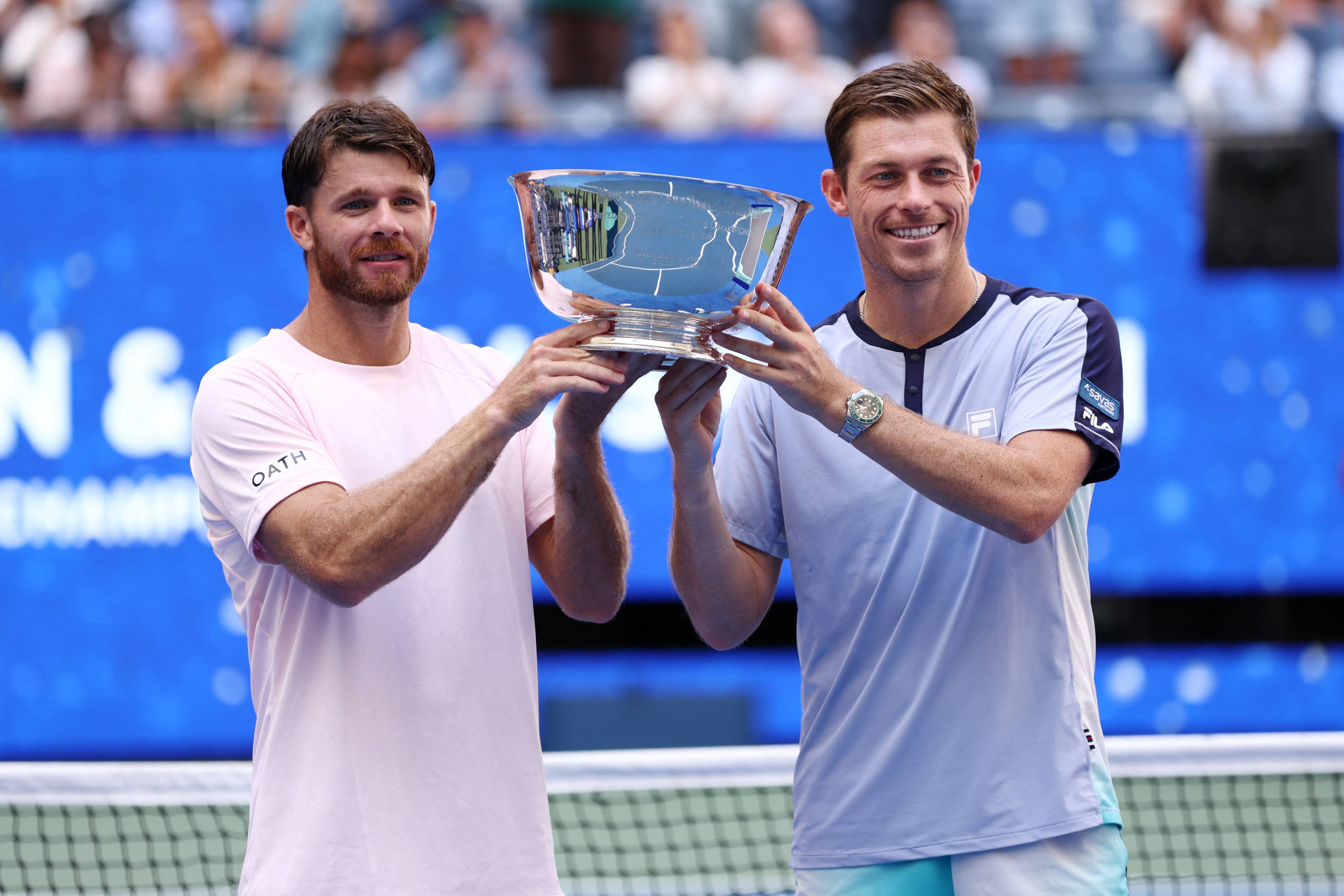Doubles tennis stars Christian Harrison and Neal Skupski holding the 2026 US Open men's doubles trophy