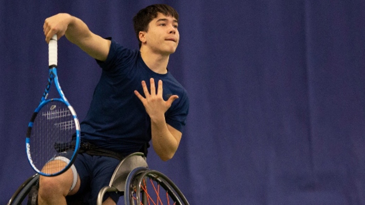 Dahnon Ward hitting a serve on the tennis court