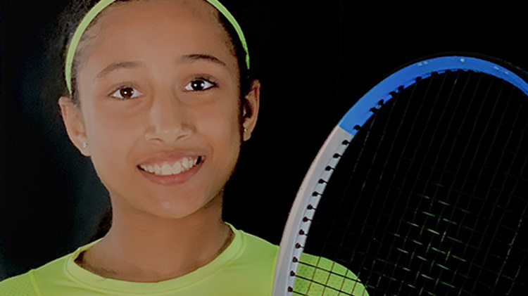 10-year-old Iraja Nagim holding a tennis racket