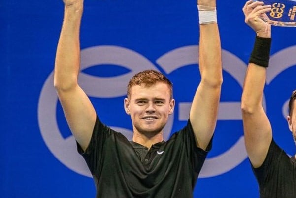 David Stevenson lifting a doubles trophy above his head in celebration