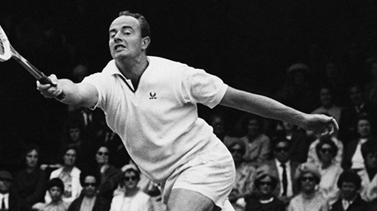 Bobby Wilson returning a shot in a tennis match with people watching