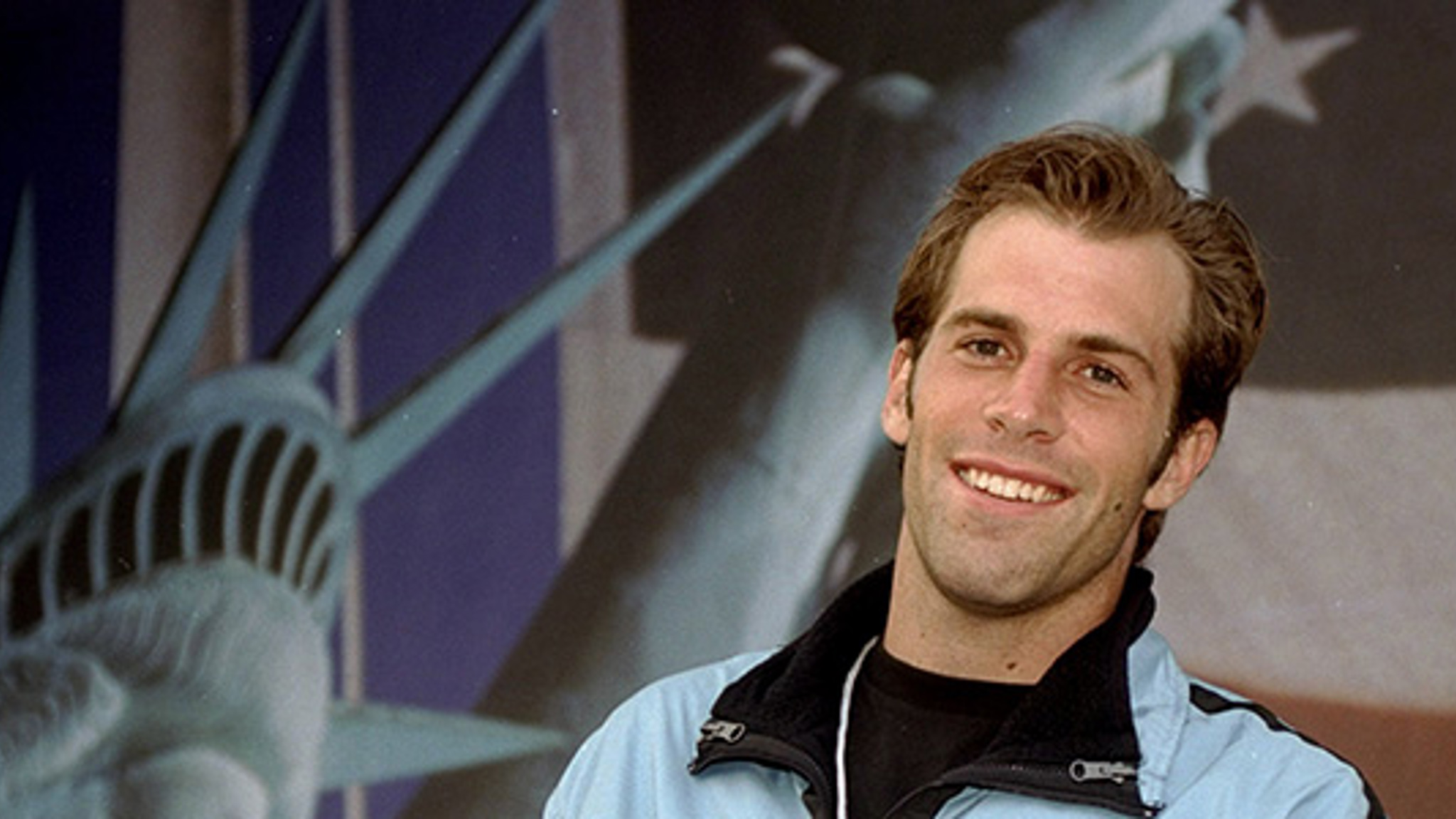 Greg Rusedski smiling with US flag in the background