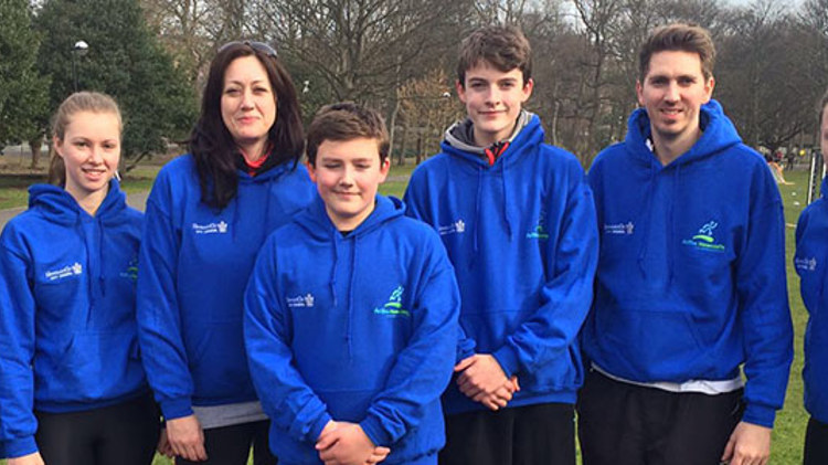 Group of people in matching blue hoodies in an open field