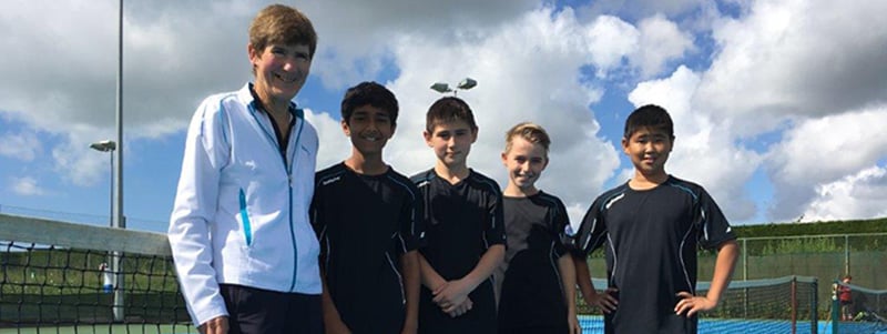 Sue Rich with four young boys on a tennis court