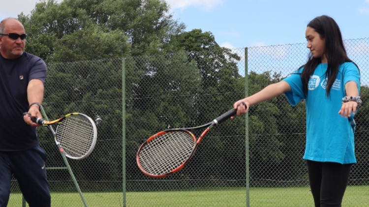 Jonty Solomons coaching a young girl at a local tennis court
