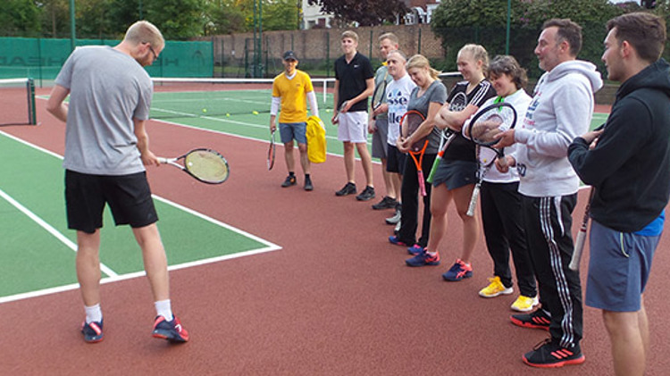 luke house on court coaching players  on  how to swing the racket